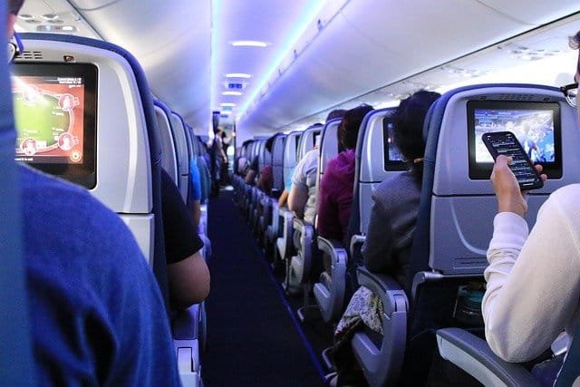 interieur d'un avion en vol avec des passagers qui regarent leur ecran