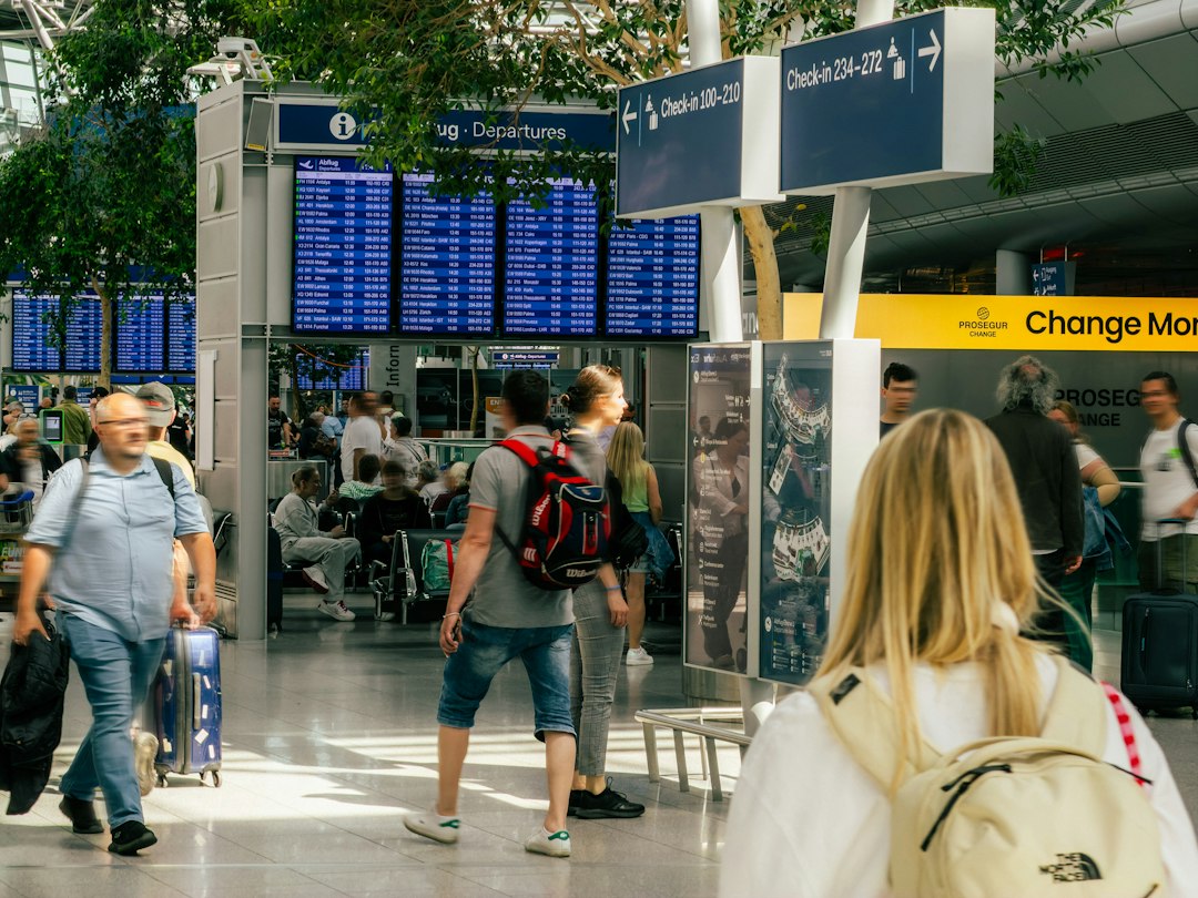 Passagers dans le hall des départs d'un aéroport en attente d'informations sur leur vol